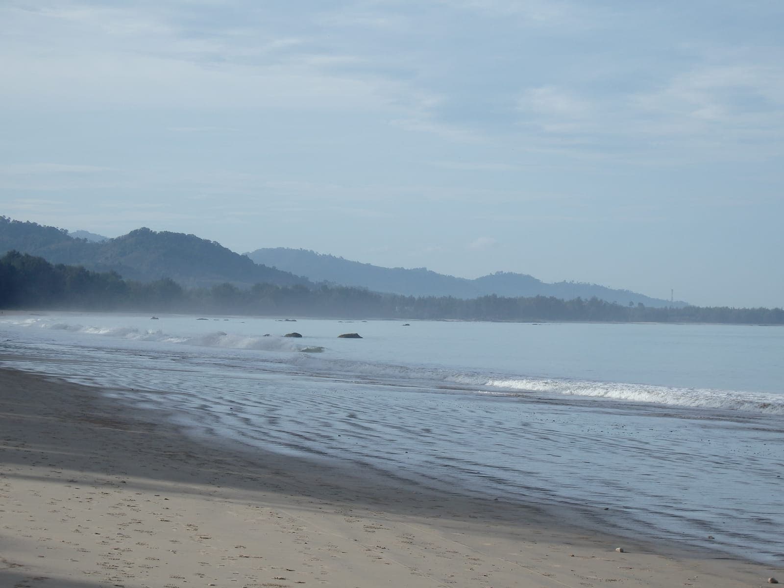 Bang Sak Beach at low tide, the hills behind in morning haze